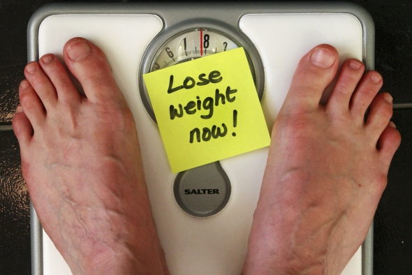 Loose weight now post-it note with feet on scale [CC]