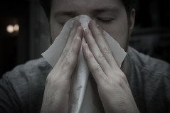 Man with a tissue suffering from allergies