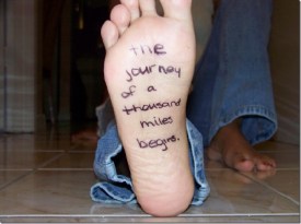 the journey of a thousand miles written on the bottom of a foot in marker